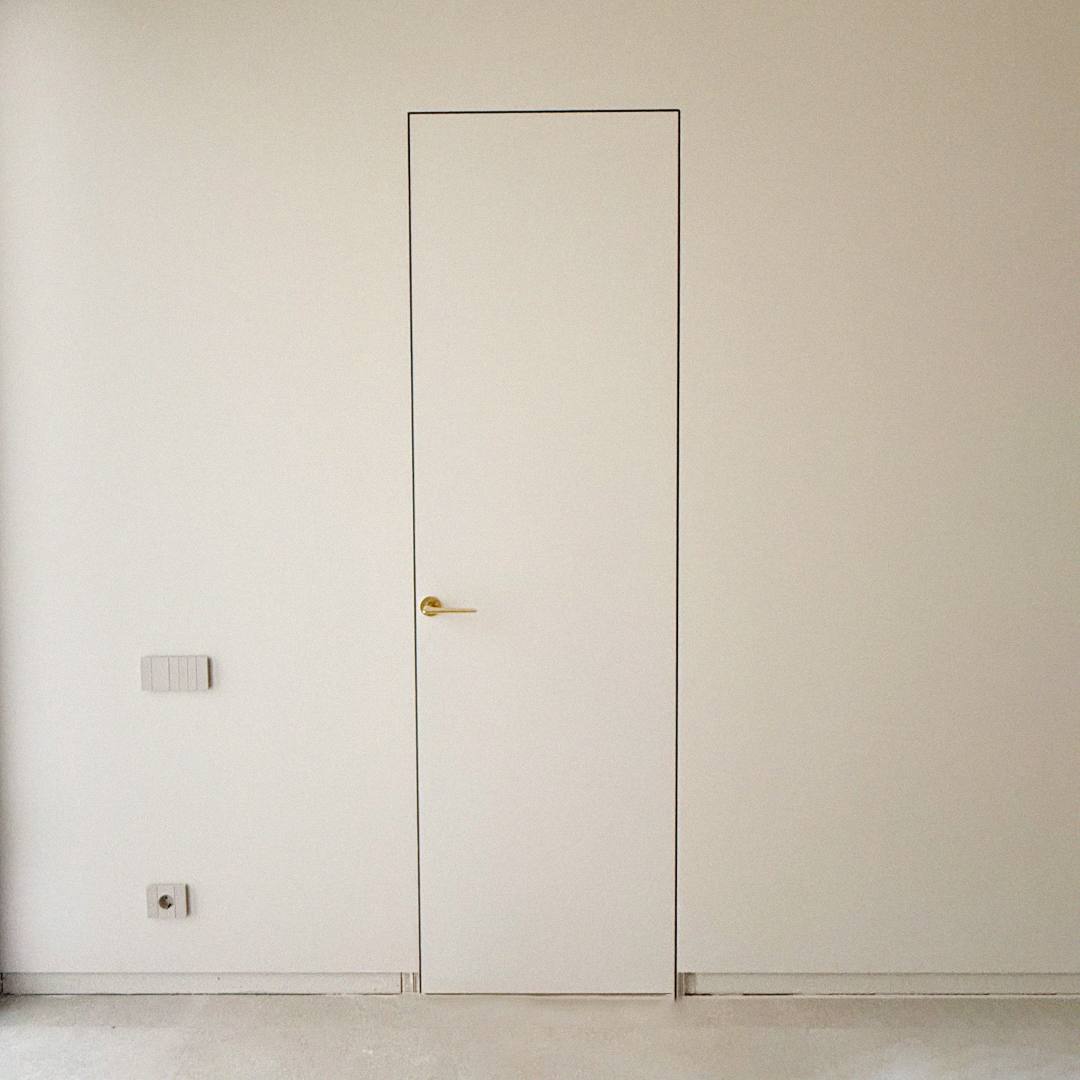 Minimalistyczne białe drzwi z ukrytą ościeżnicą